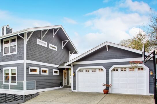 grey home with white garage doors